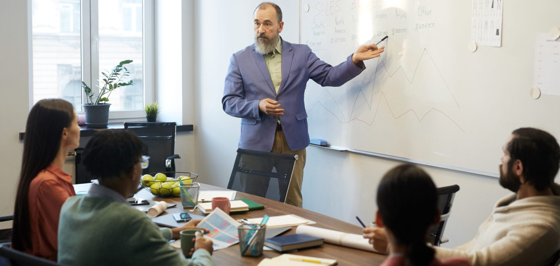Professional business analyst demonstrating stats on whiteboard in modern office board room during meeting, copy space